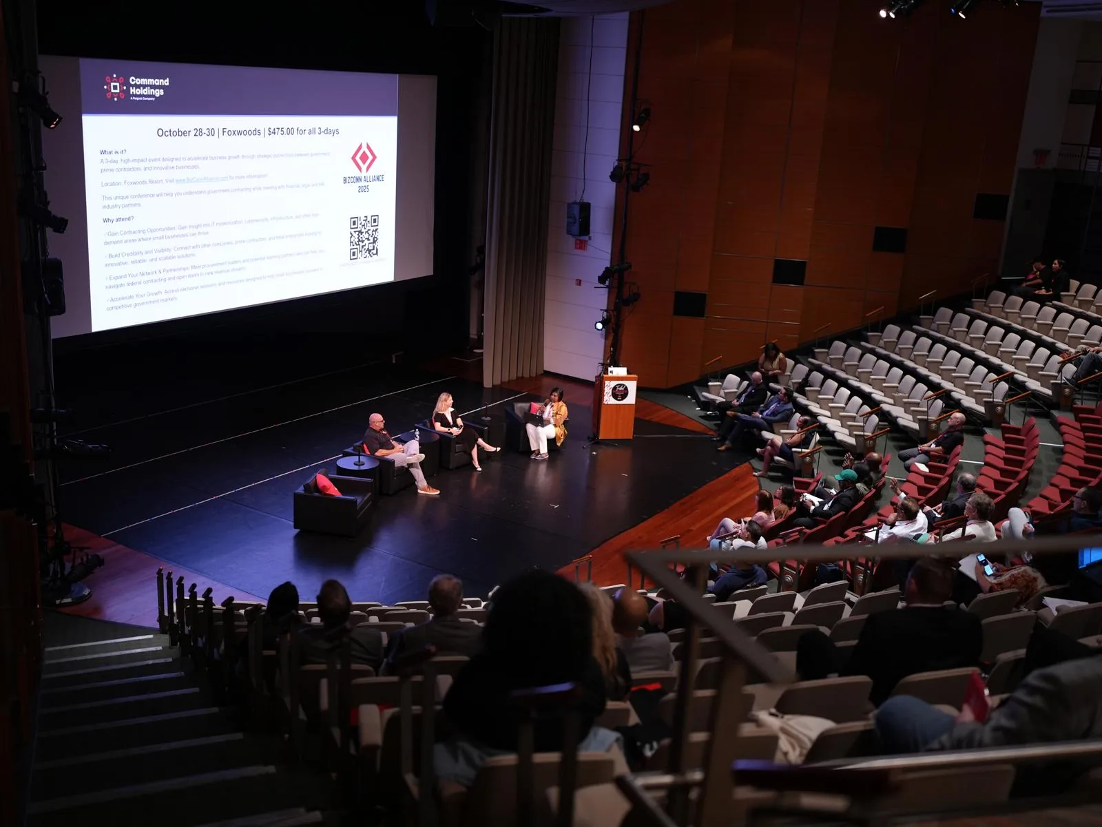 Panel discussion on stage before a full audience at a Connecticut business summit