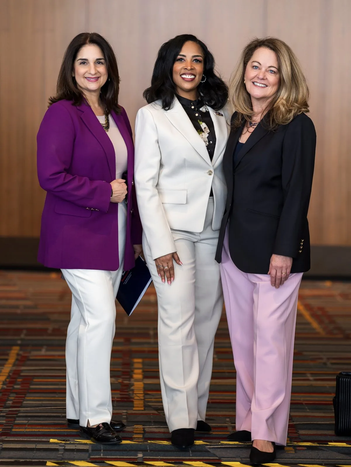 Three businesswomen photographed together at a Connecticut business conference
