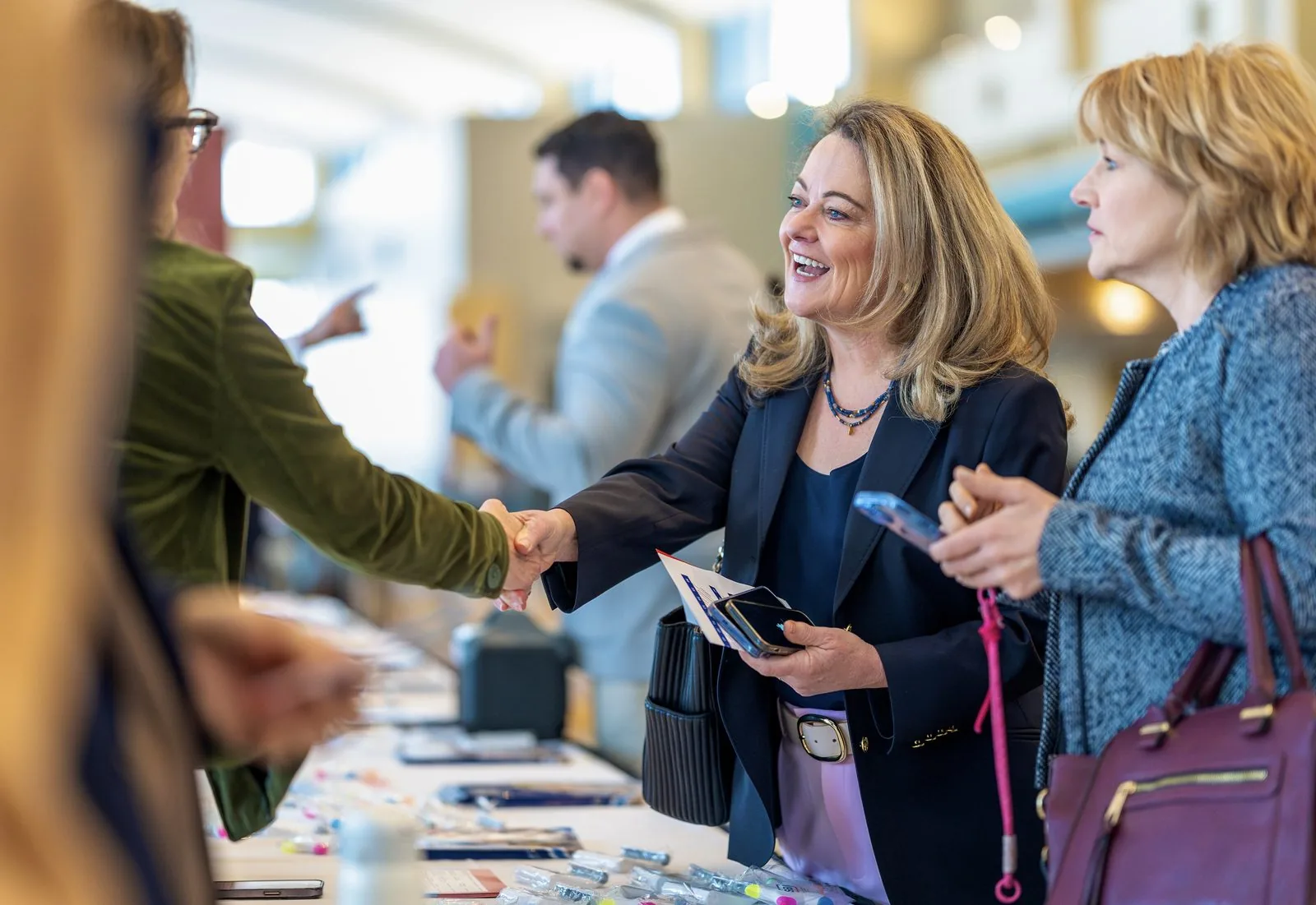Candid handshake at a conference registration table, corporate event photography in Connecticut