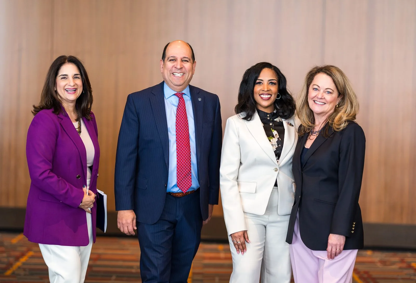 Four executives photographed at a corporate symposium in Connecticut