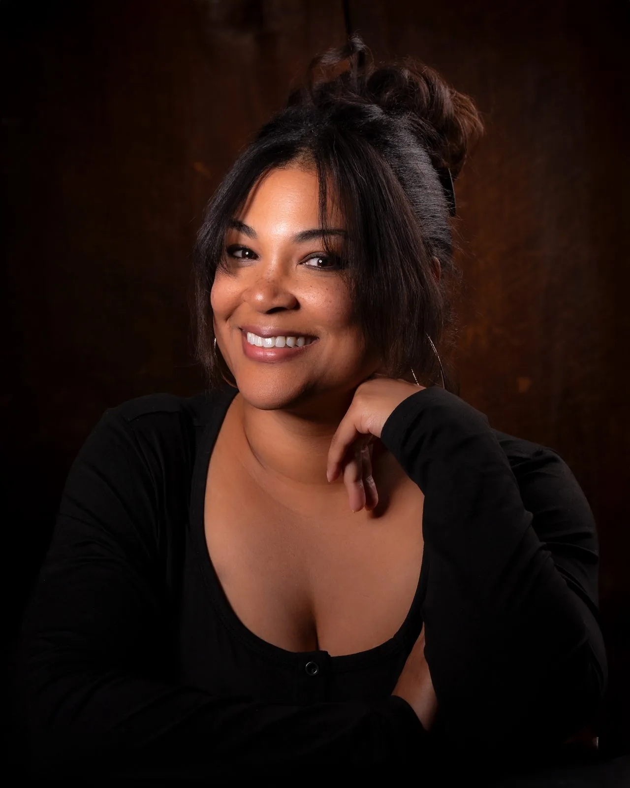 Warm smiling studio portrait of a woman against a rich brown backdrop, Connecticut portrait studio