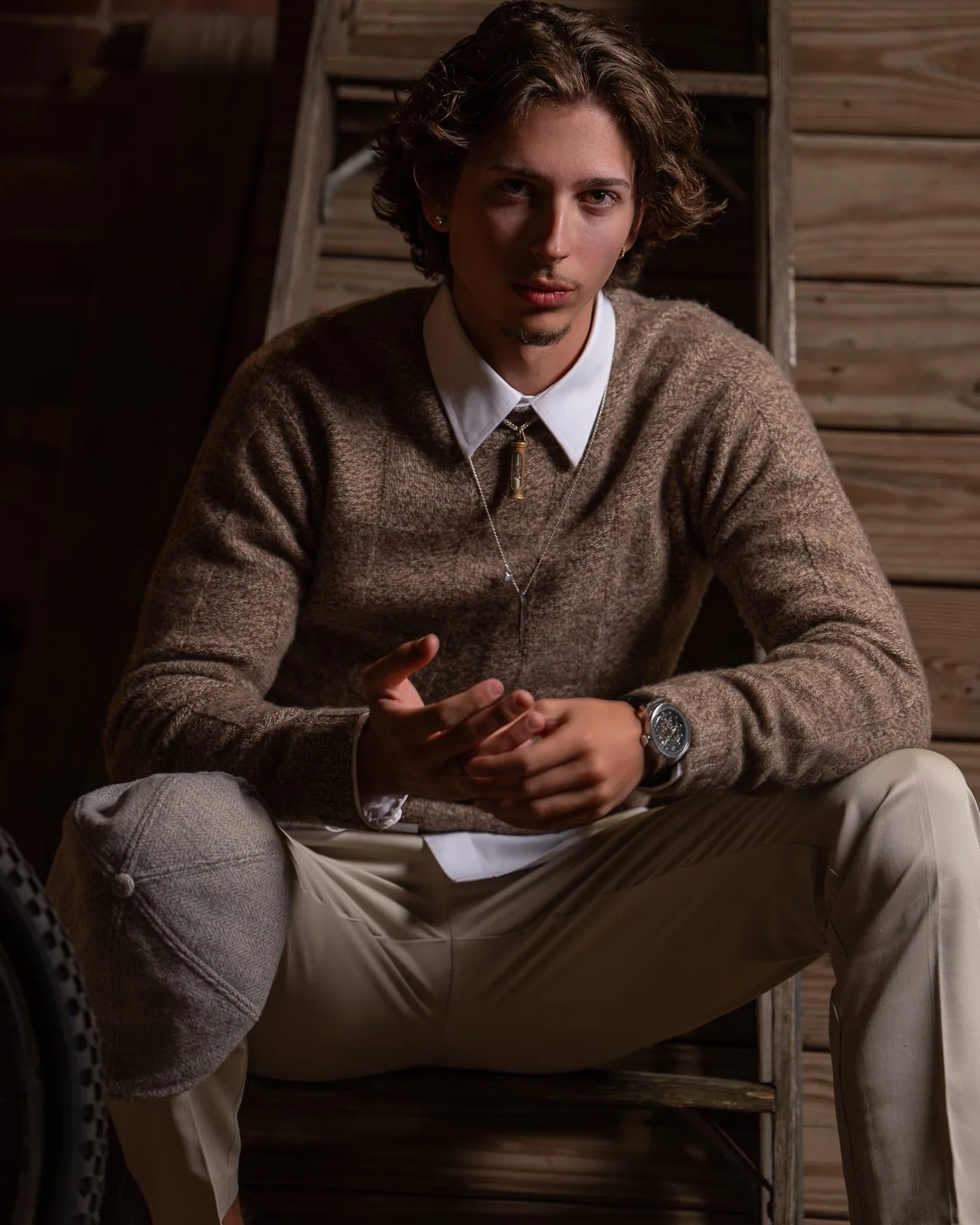 Moody senior portrait of a young man in a barn setting — Class of 2027 senior photography in Connecticut