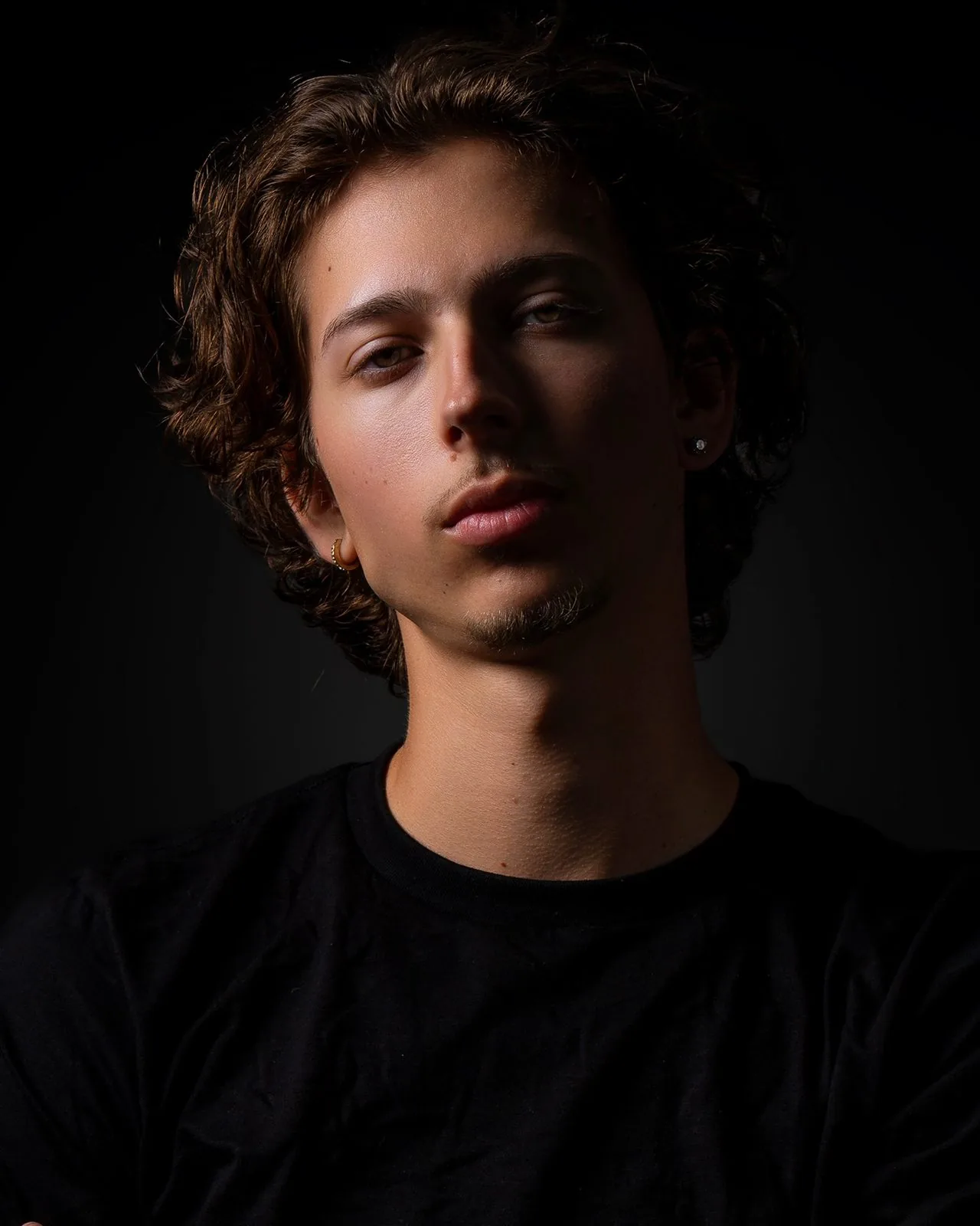 Dramatic low-key studio senior portrait of a Class of 2027 young man, Connecticut